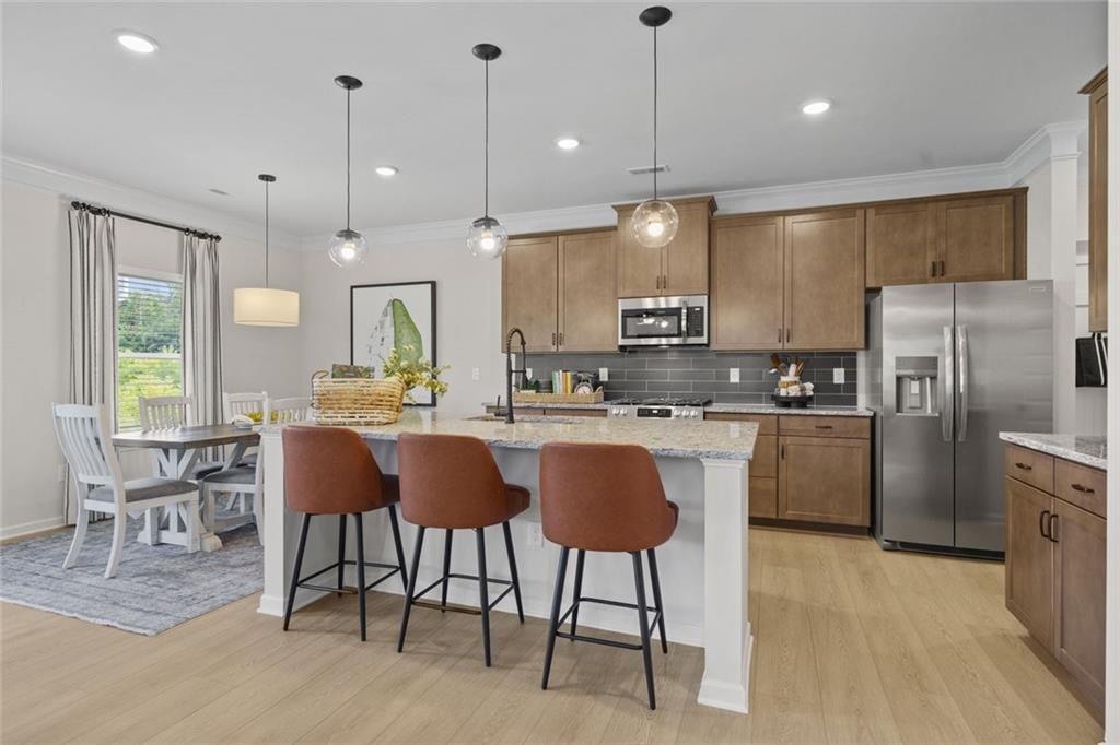 156 Saddle Ridge Trail Jasper, GA 30143 - Photo 8 of 45 a kitchen with stainless steel appliances granite countertop a refrigerator a stove a sink dishwasher a dining table and chairs with wooden floor