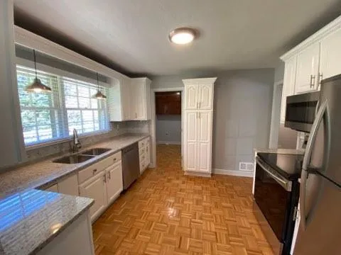 a kitchen with stainless steel appliances a stove a sink and a refrigerator