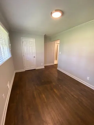 an empty room with wooden floor and windows in it