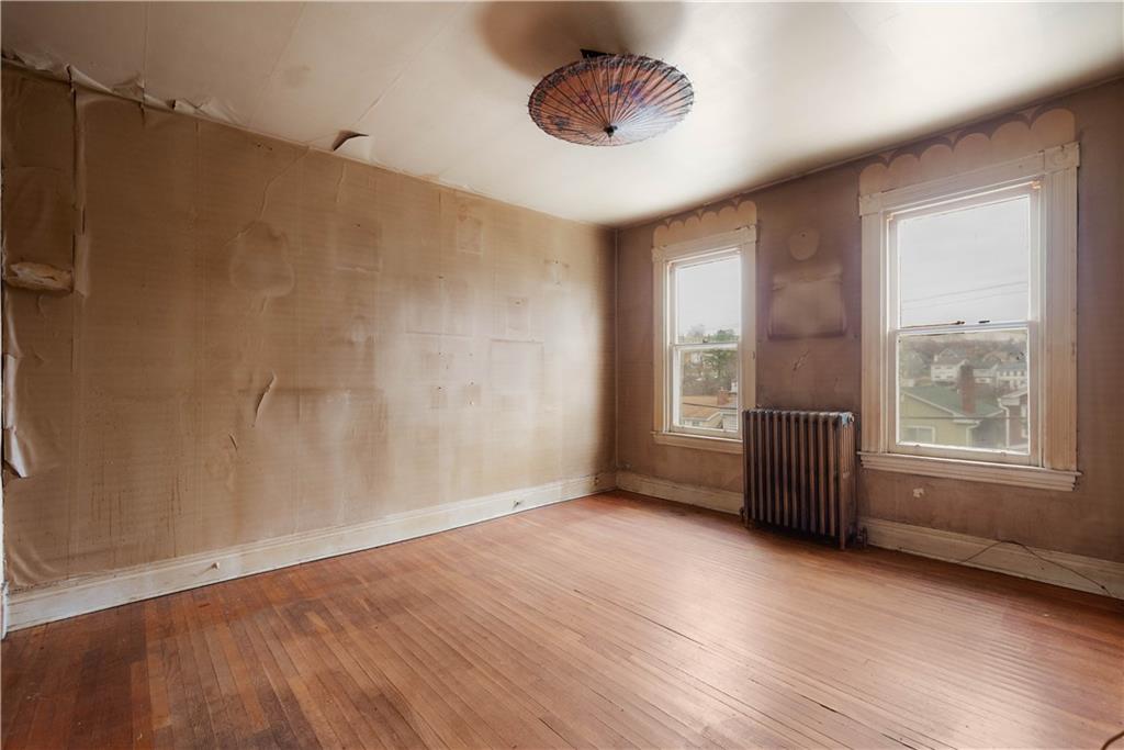208 Linnview Avenue Pittsburgh, PA 15210 - Photo 13 of 26 a view of an empty room with a window and wooden floor