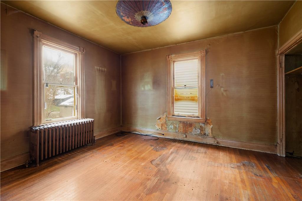 208 Linnview Avenue Pittsburgh, PA 15210 - Photo 14 of 26 an empty room with wooden floor and windows