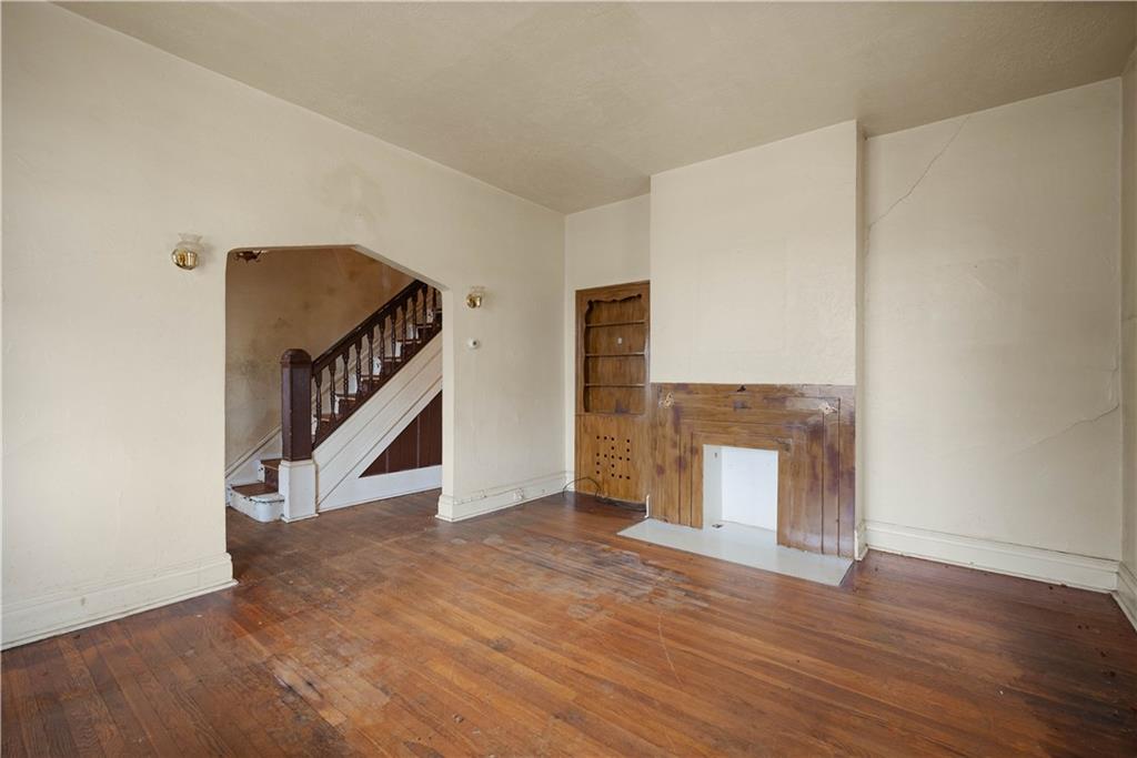 208 Linnview Avenue Pittsburgh, PA 15210 - Photo 15 of 26 a view of an empty room with wooden floor and stairs