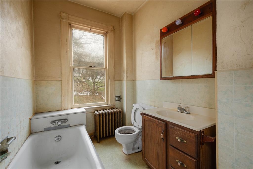 208 Linnview Avenue Pittsburgh, PA 15210 - Photo 25 of 26 a bathroom with a granite countertop sink toilet a mirror and bathtub