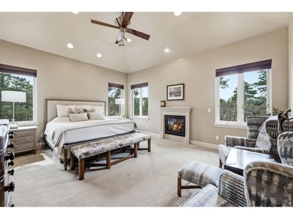 a spacious bedroom with a bed a couch and a fireplace