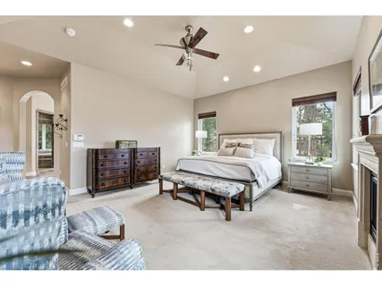 a spacious bedroom with a bed a dresser and potted plant