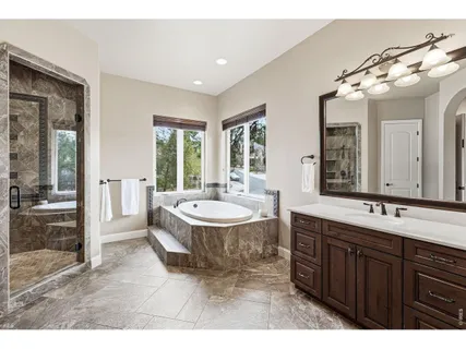 a spacious bathroom with a tub sink and mirror