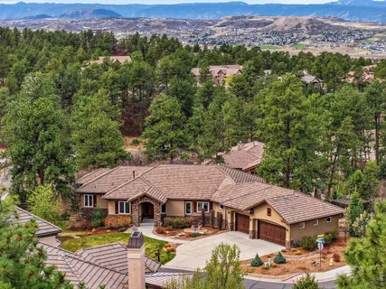an aerial view of a house with swimming pool and trees