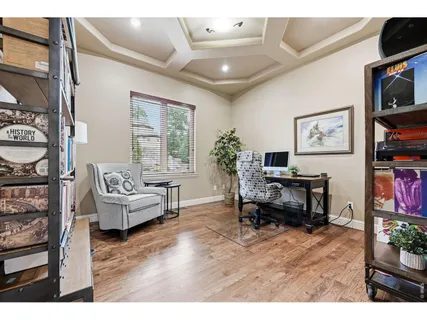 a living room with furniture and a flat screen tv with kitchen view