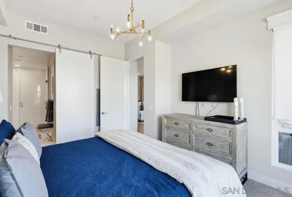 a bedroom with a bed a chandelier and a closet