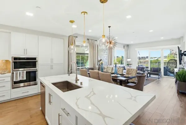 a large kitchen with kitchen island a large counter top appliances and a view of living room
