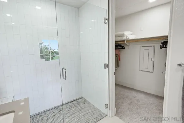 a view of a hallway with wooden floor and a bathroom
