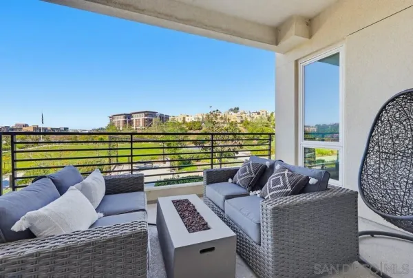 a front view of a multi story residential apartment building with yard and bench