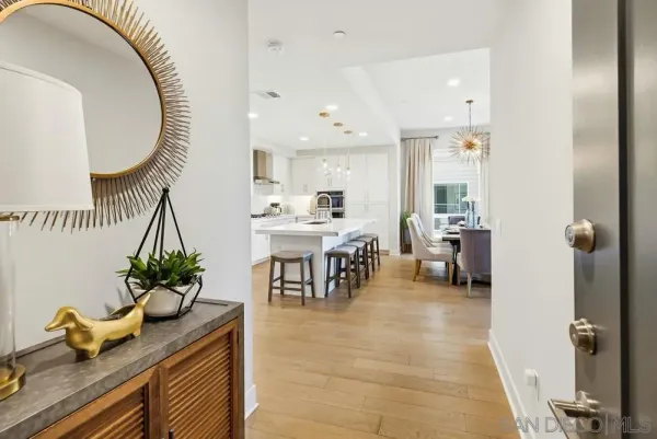 a kitchen with stainless steel appliances kitchen island granite countertop a sink a stove a dining table and chairs with wooden floor