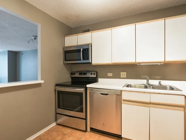 a kitchen with a sink cabinets and stainless steel appliances