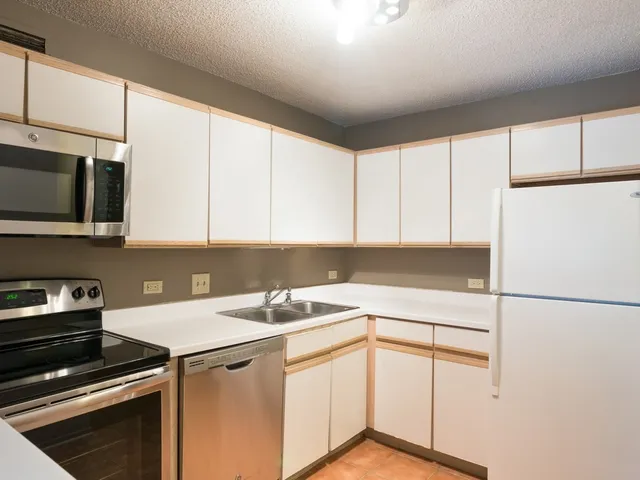 a kitchen with a sink cabinets and appliances