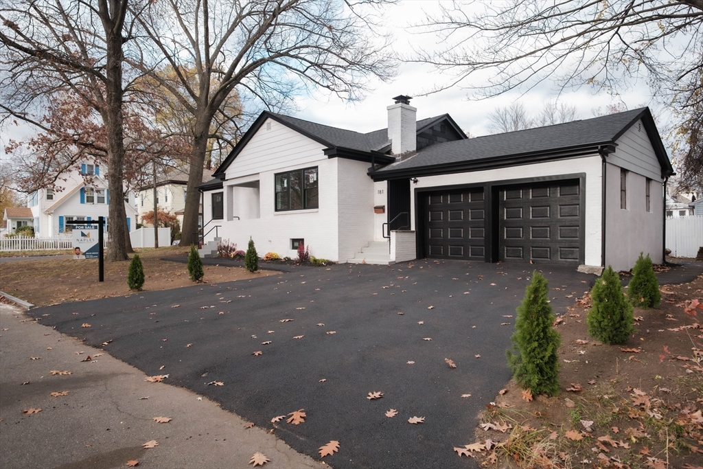 a view of a white house with a large tree