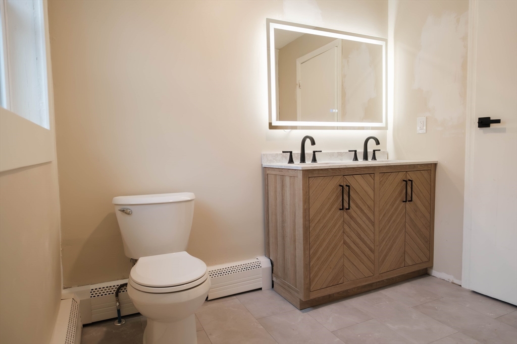 181 Freeman Terrace Springfield, MA 01104 - Photo 24 of 37 a bathroom with a toilet sink vanity and mirror