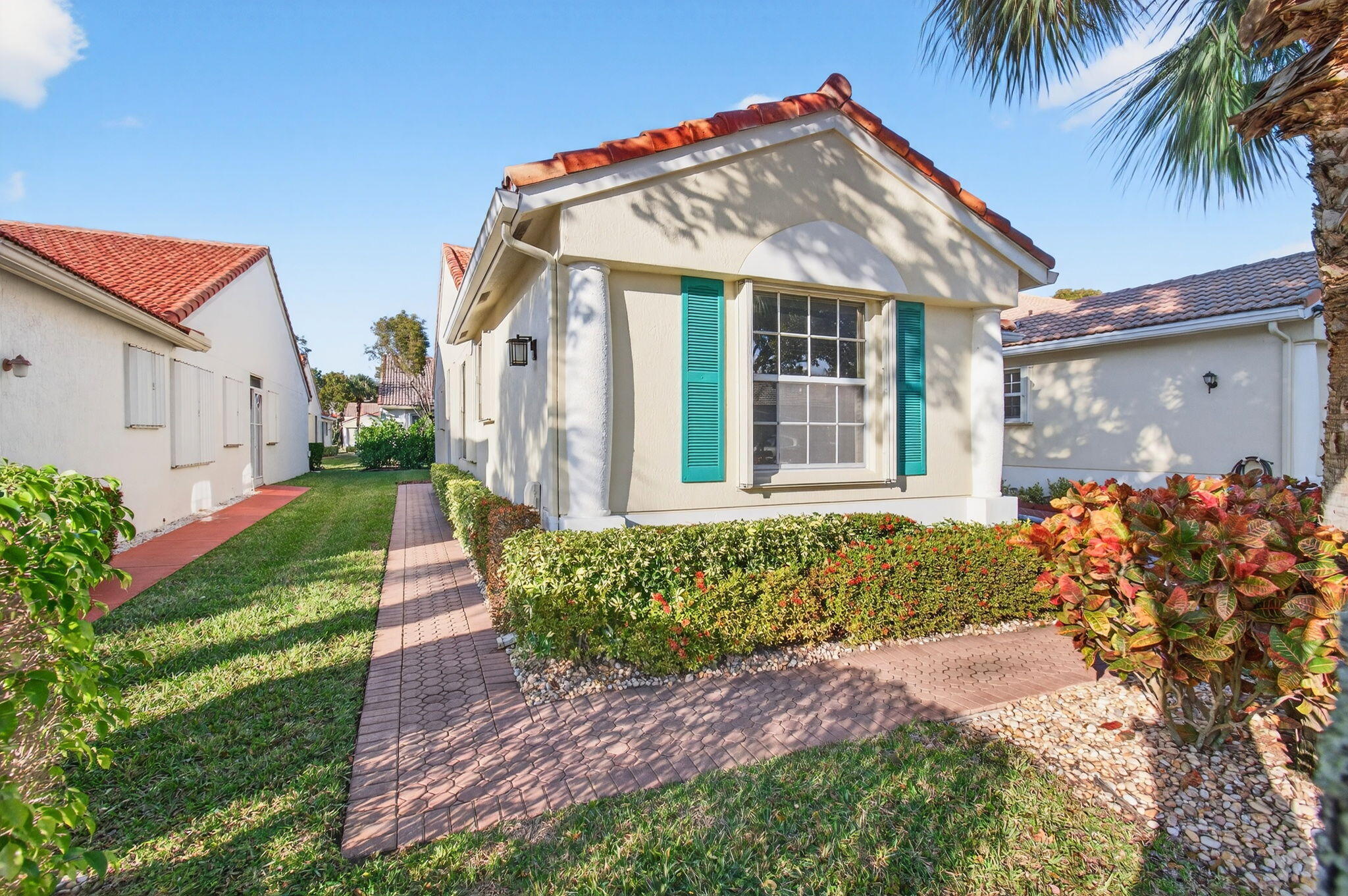6253 Heliconia Road Delray Beach, FL 33484 - Photo 2 of 85 a front view of a house with a garden