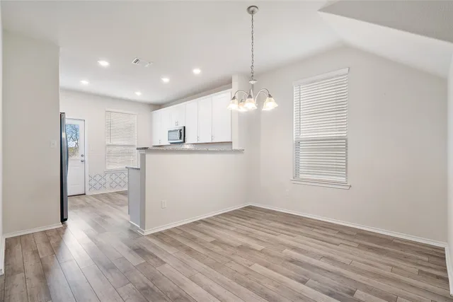 a view of a kitchen with wooden floor and a window