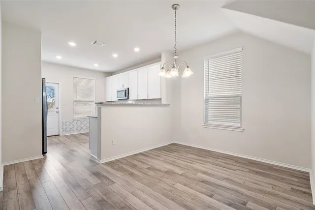 a view of a kitchen with wooden floor and a window