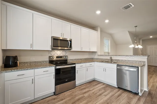 a kitchen with granite countertop white cabinets and white appliances