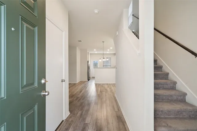 a view of a hallway with wooden floor and staircase