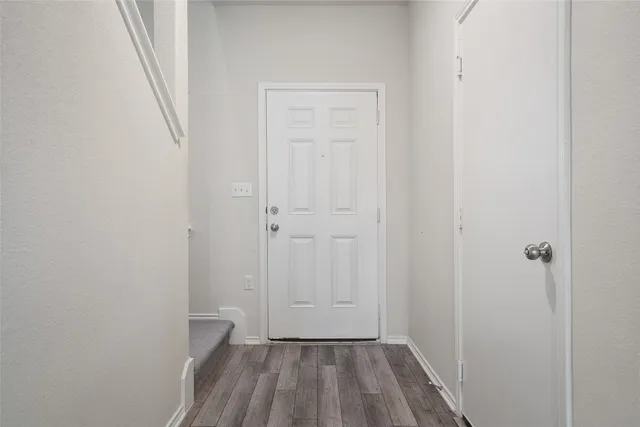 a view of a room with wooden floor and a small space