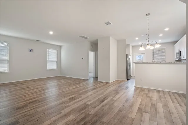 a view of a room with wooden floor and kitchen view