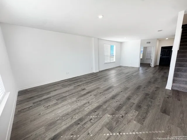 a view of empty room with wooden floor