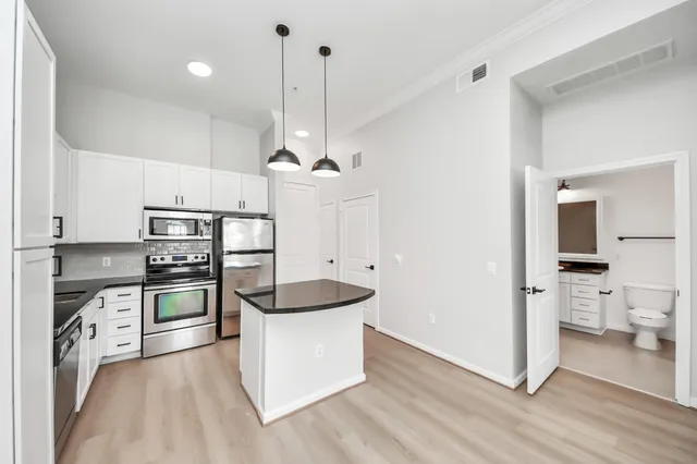 a kitchen with stainless steel appliances a stove a sink and a refrigerator