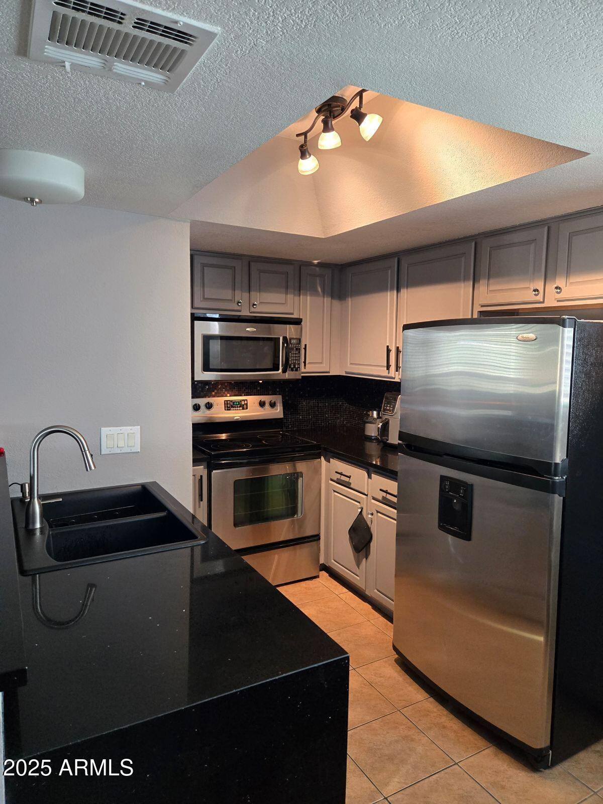 1720 East Thunderbird Road, Unit 2015 Phoenix, AZ 85022 - Photo 15 of 25 a kitchen with kitchen island a sink appliances and cabinets