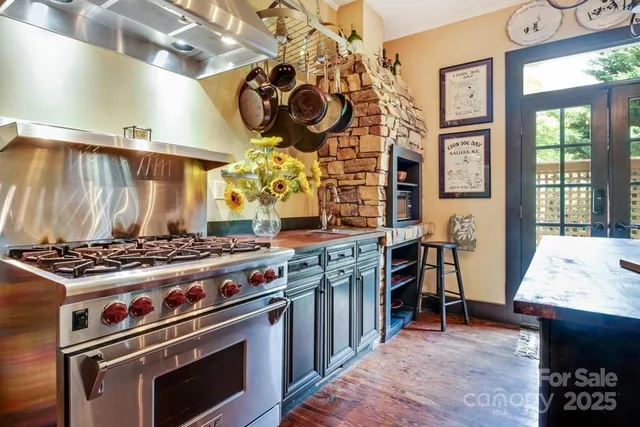 a kitchen with a stove and a wooden floor