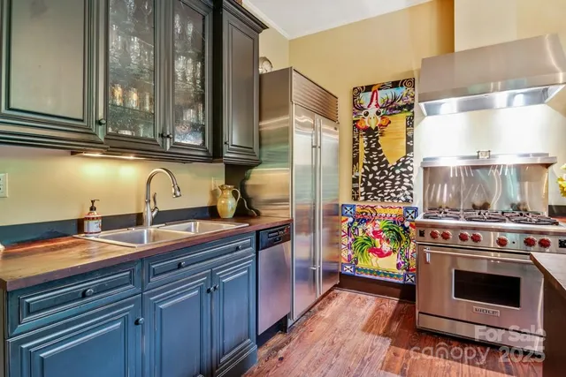 a kitchen with stainless steel appliances a stove a sink and a microwave