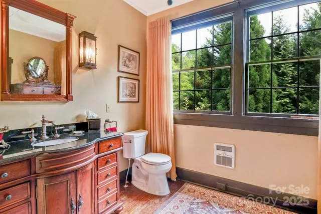 a bathroom with a sink a toilet and a window