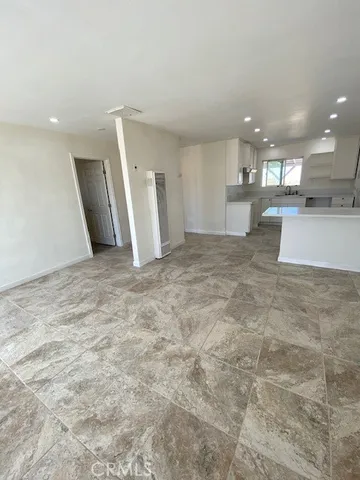 a large kitchen with kitchen island granite countertop a sink a counter top space and cabinets
