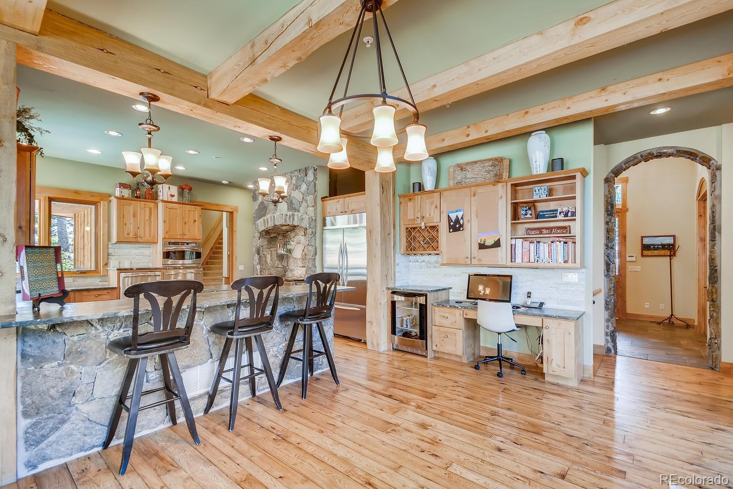 150 Outpost Lane Evergreen, CO 80439 - Photo 14 of 40 a dining room with wooden floor a chandelier a wooden table and chairs