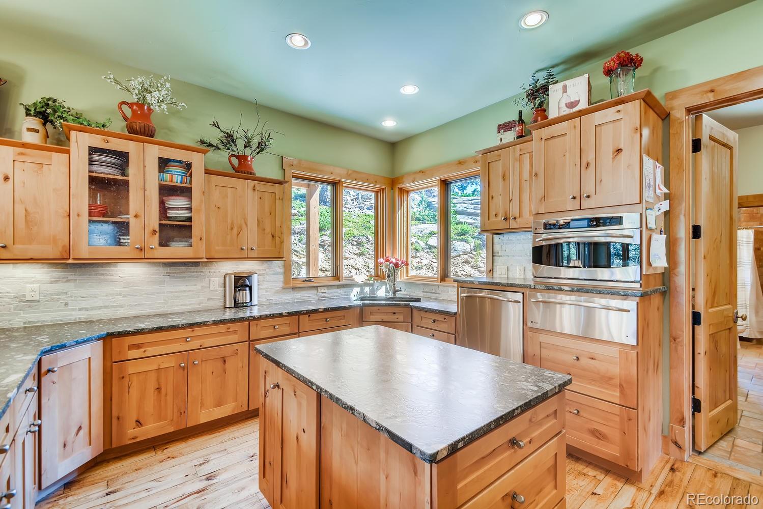 150 Outpost Lane Evergreen, CO 80439 - Photo 15 of 40 a kitchen with stainless steel appliances granite countertop a sink and dishwasher a stove with wooden floor
