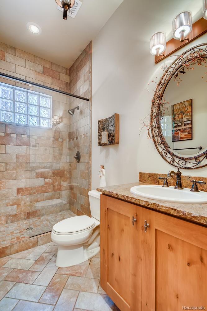 150 Outpost Lane Evergreen, CO 80439 - Photo 19 of 40 a bathroom with a granite countertop sink mirror vanity and toilet