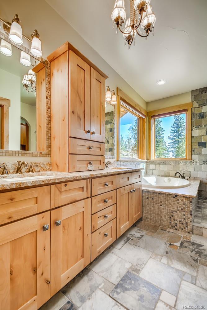 150 Outpost Lane Evergreen, CO 80439 - Photo 23 of 40 a spacious bathroom with a granite countertop sink mirror and a bathtub