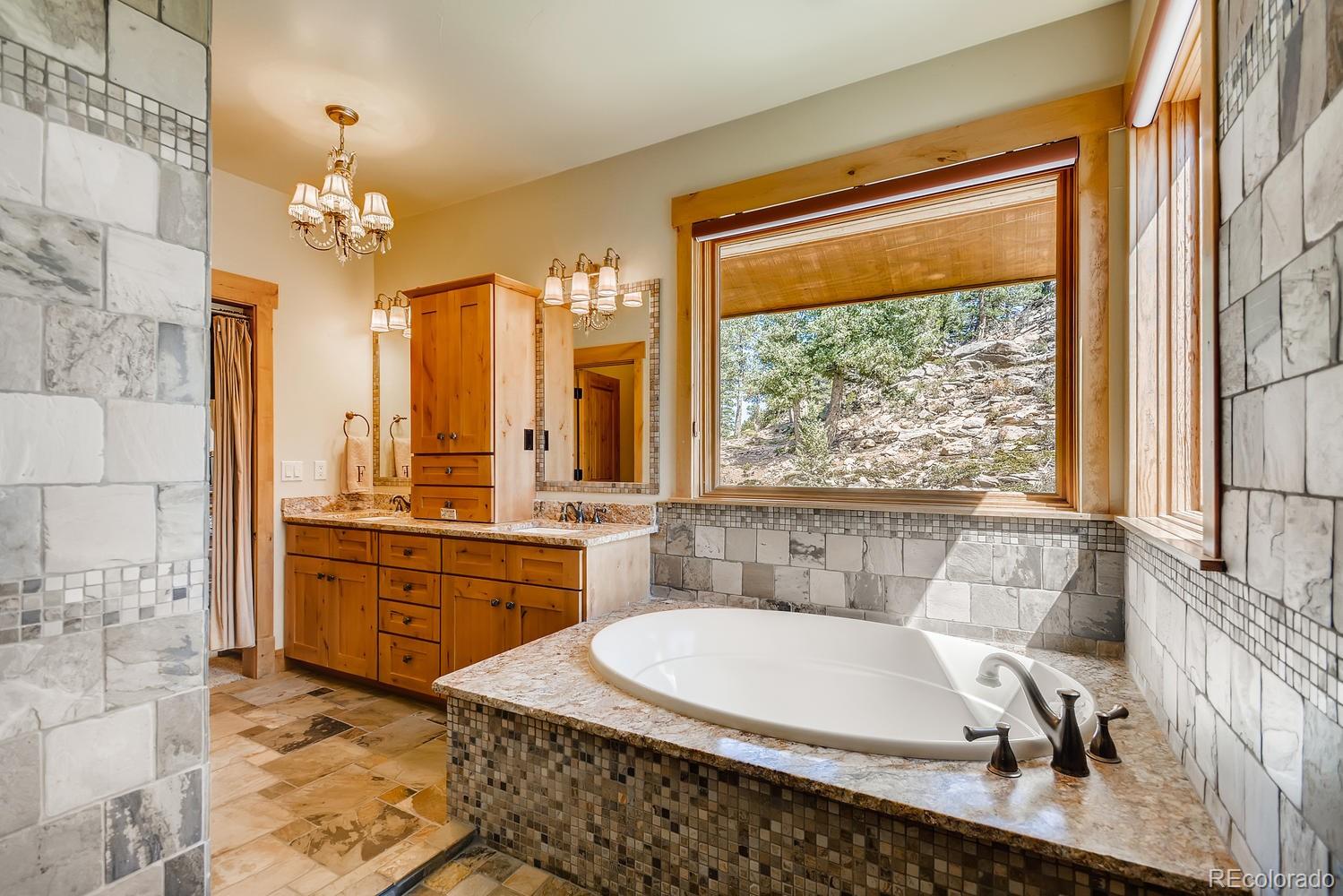 150 Outpost Lane Evergreen, CO 80439 - Photo 25 of 40 a large white kitchen with a large window