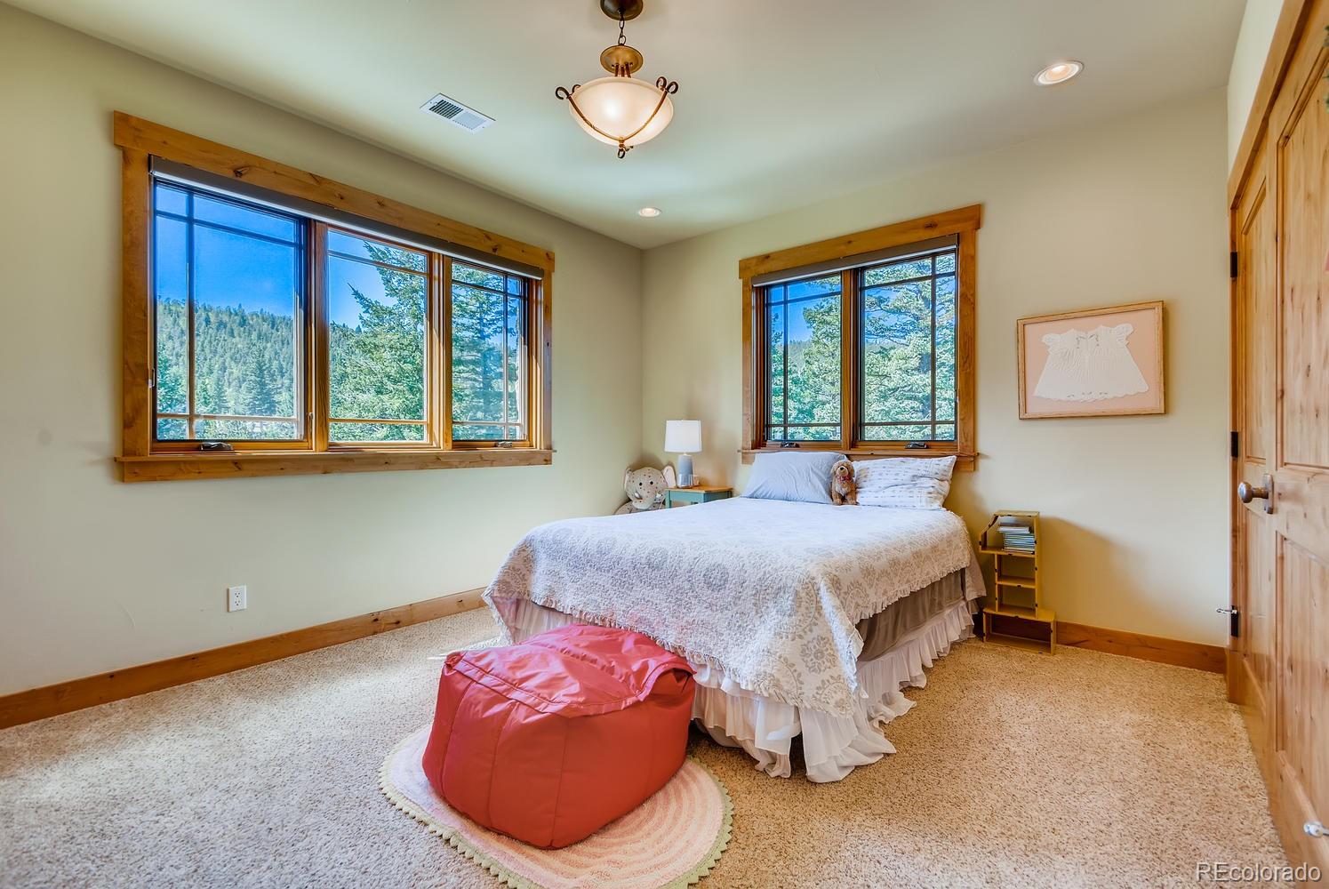 150 Outpost Lane Evergreen, CO 80439 - Photo 27 of 40 a bedroom with a bed and a window