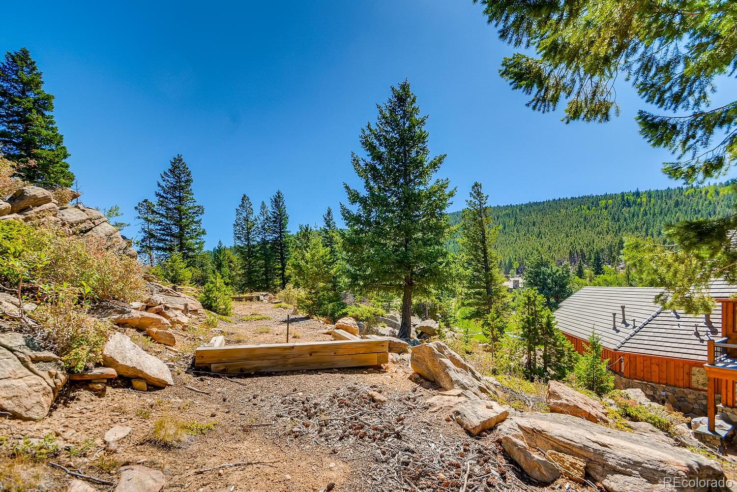 150 Outpost Lane Evergreen, CO 80439 - Photo 36 of 40 a view of a backyard with plants and a patio