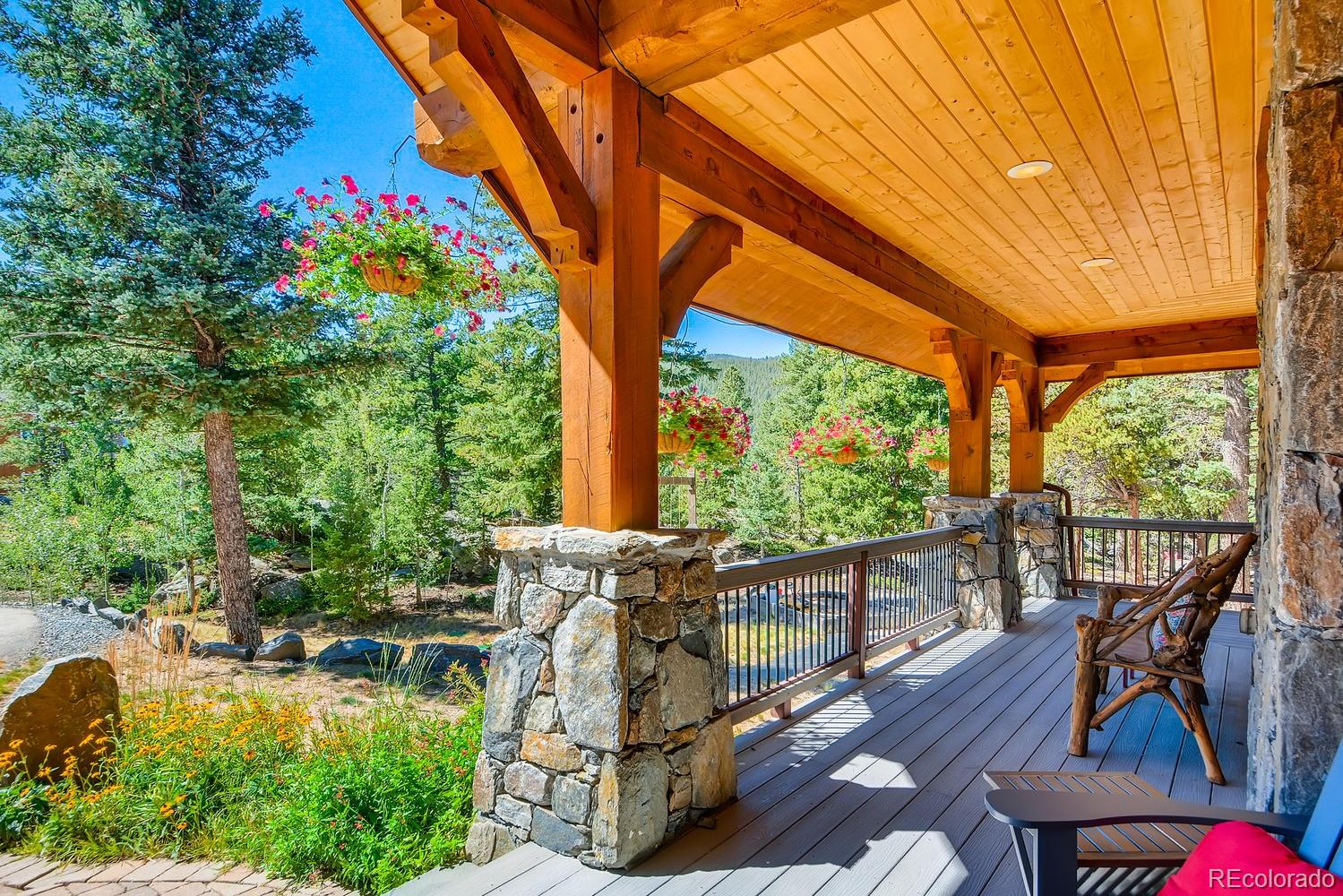 150 Outpost Lane Evergreen, CO 80439 - Photo 38 of 40 a view of a patio with table and chairs potted plants with wooden floor and fence