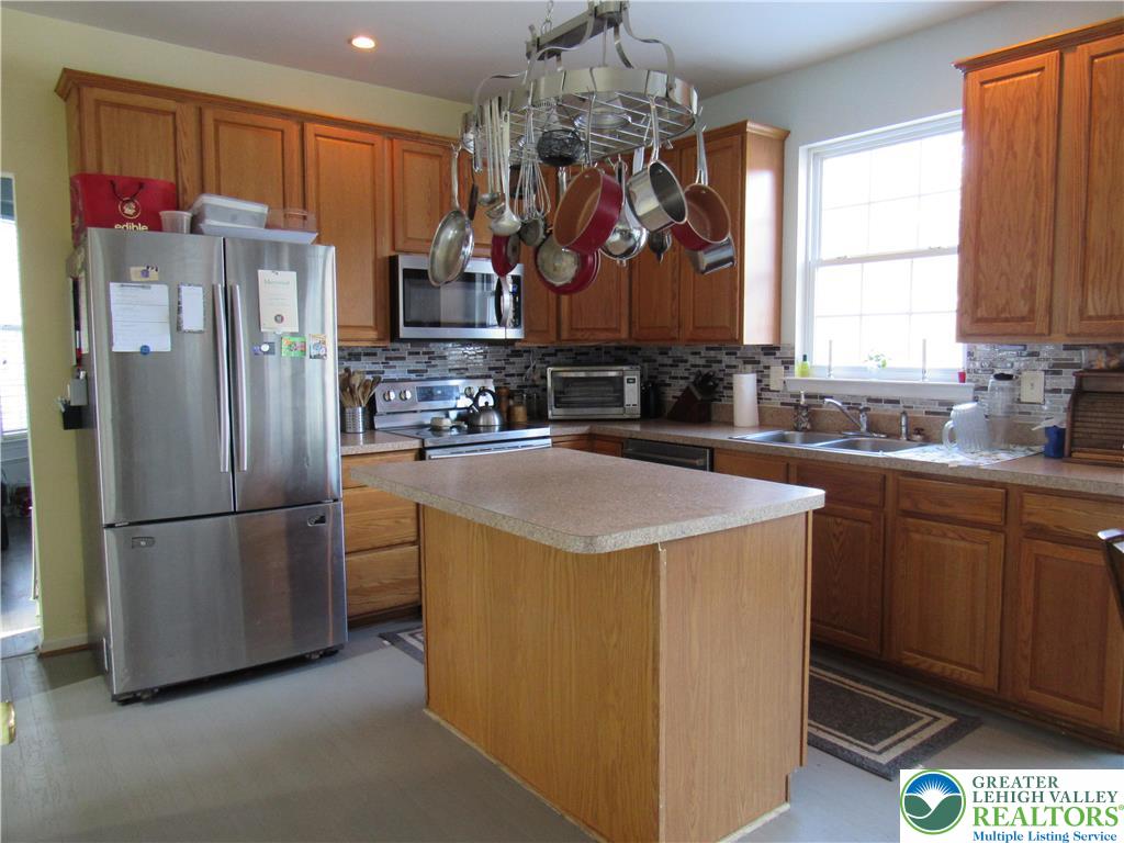 17 Wilt Road Bechtelsville, PA 19505 - Photo 17 of 38 a kitchen with stainless steel appliances granite countertop a refrigerator a sink dishwasher a oven with a dining table and chairs