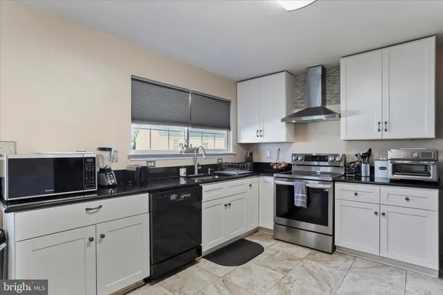 a kitchen with white cabinets and appliances