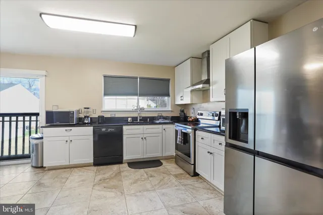 a kitchen with stainless steel appliances granite countertop a refrigerator sink and stove