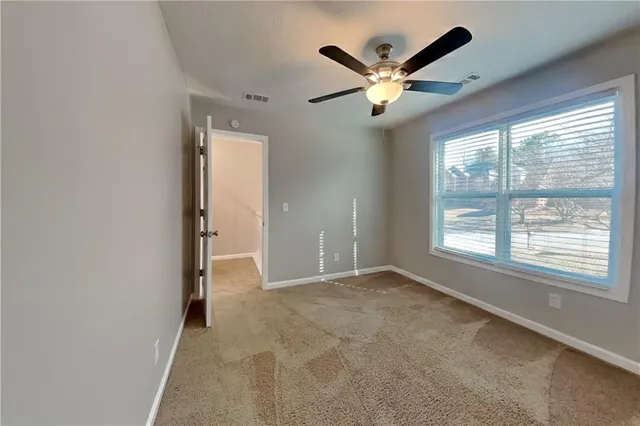 a view of a livingroom with a ceiling fan and window