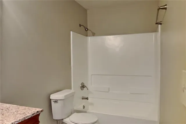 a bathroom with a shower a toilet and sink