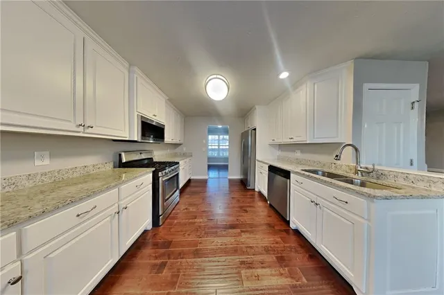 a large kitchen with stainless steel appliances granite countertop a lot of counter space and wooden cabinets