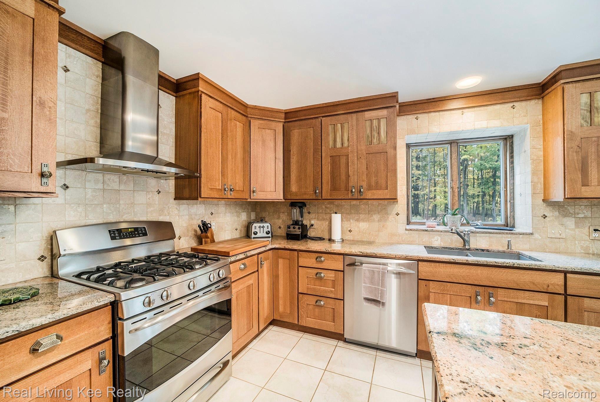 2631 Harrington Road Rochester, MI 48307 - Photo 22 of 38 Remodeled kitchen with custom cabinetry, granite counters, ceramic backsplash, ss appliances and porcelain tile.